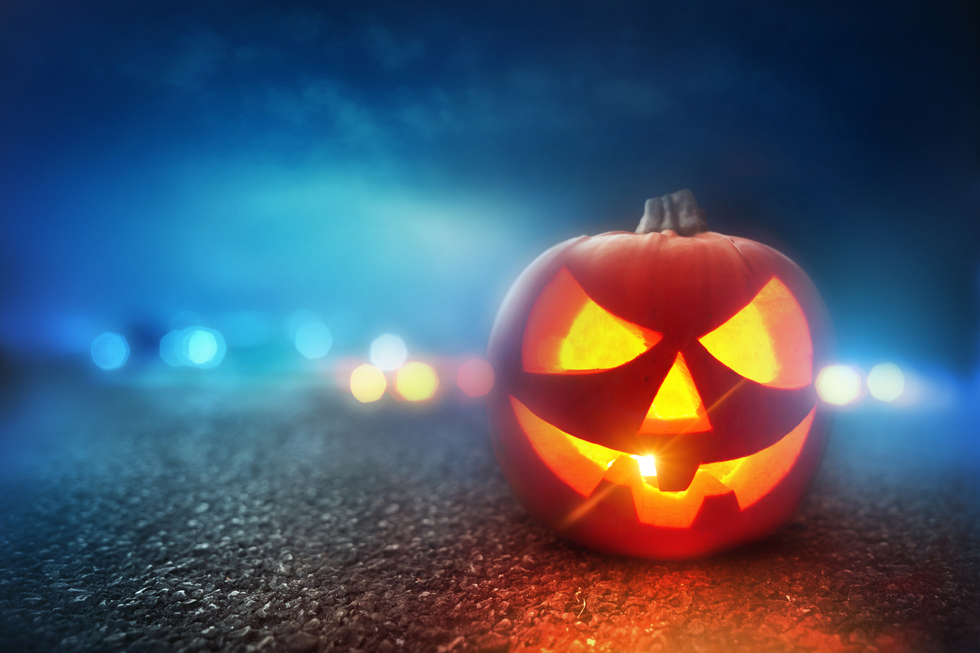 Jack-o-lantern on misty road with blue haze in background, stop scaring yourself.