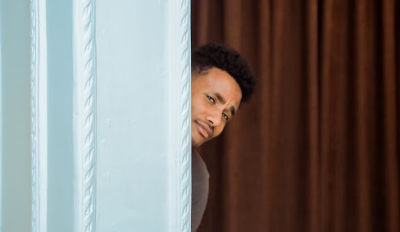 Man quizzically peering from behind a blue wall wondering about trust and divorce recovery.