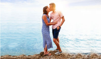 Couple on a cliff overlooking the sea kissing because they&#039;ve each found the ability to trust after divorce.