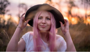 Woman with pink hair looking confused about name calling being OK.