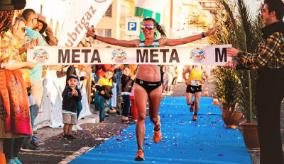 Woman running through the finish line.