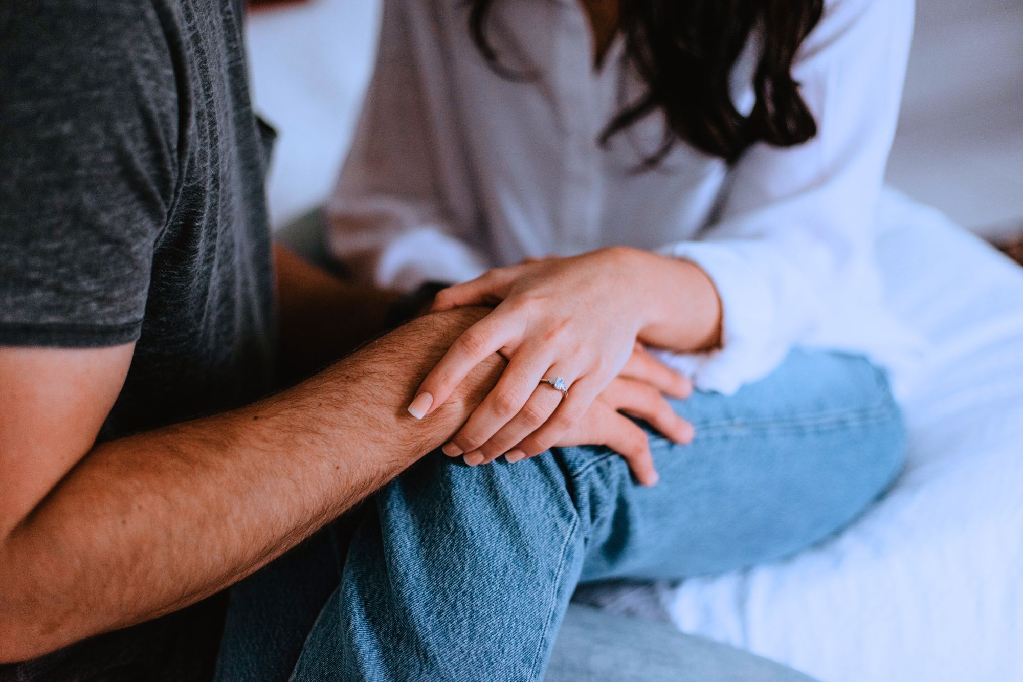 close up of husband and wife holding hands as they consider 13 Ways You Can Improve Your Unhappy Marriage