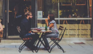 Couple sitting at an outside cafe on a date.