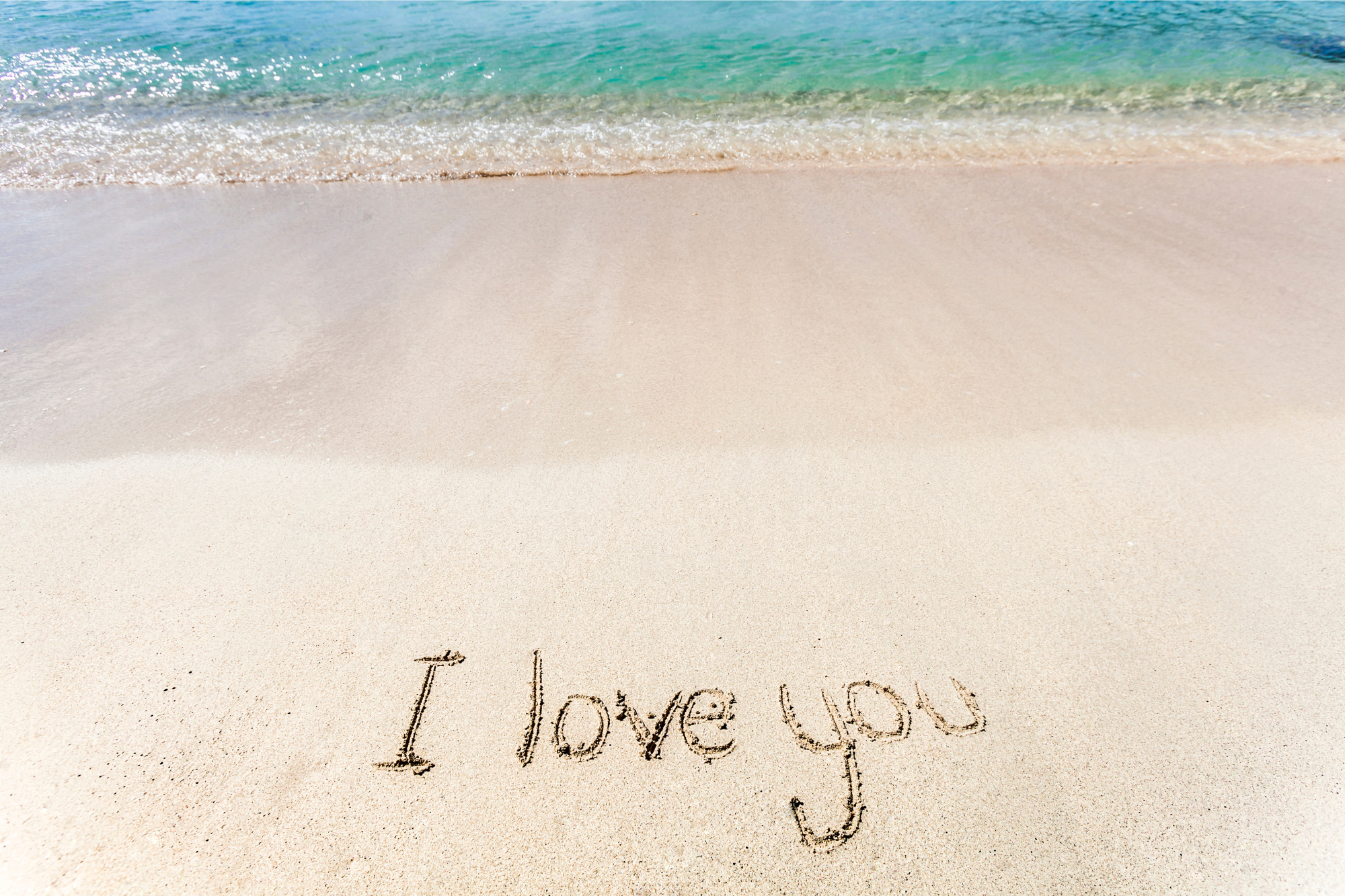 I love you written in the sand at the beach