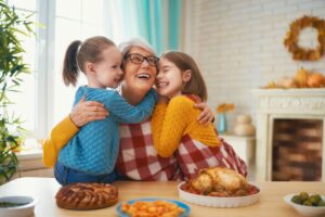 Grandmother hugging granddaughters to give them the gift of a guilt-free holiday