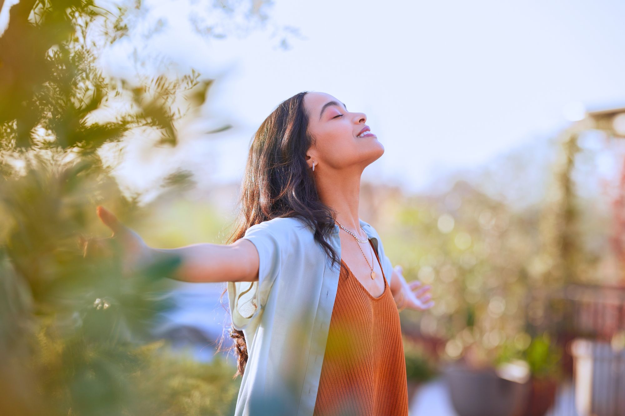 Woman outside with eyes closed and arms raised wondering "Can I save my marriage with gratitude?".