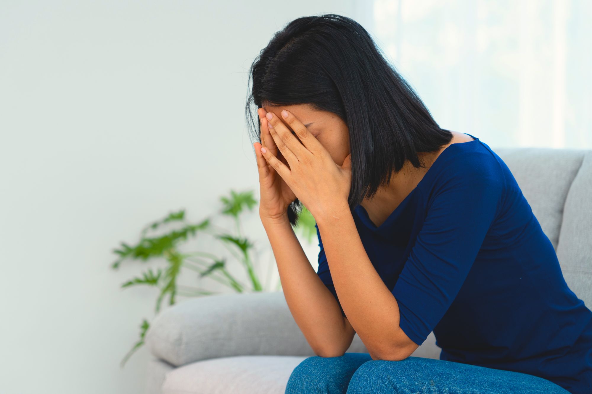 Sad woman sitting with her head in her hands wondering how to heal divorce heartbreak so you can move on with life.