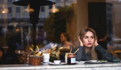 Woman in restaurant stuck in a world of negative thoughts.