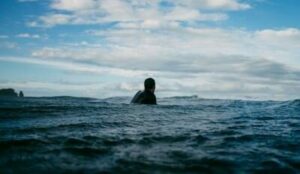 man or surfer in ocean alone