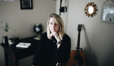 Woman sitting on a chair, holding her chin and struggling with negative thoughts.