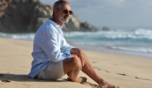 Man sitting on the beach contemplating his life after a divorce at 50.