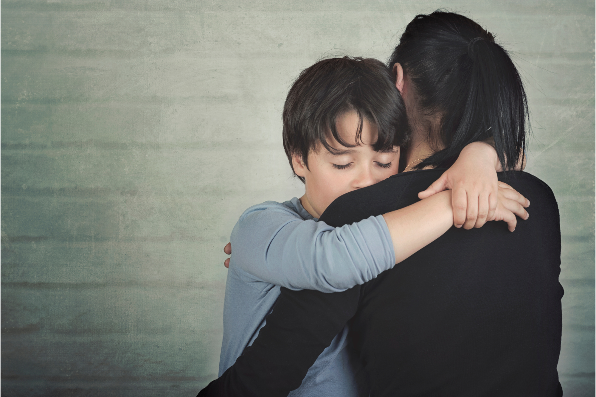 Mother hugs her son as she plans how to win custody of him against her narcissistic ex.