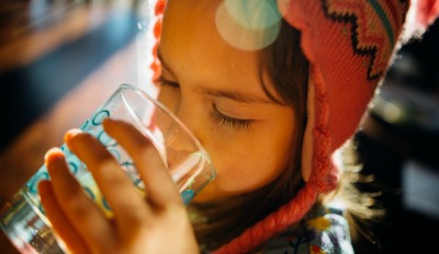 Girl drinking water unaware her parent is watching &amp; thinking about co-parenting with a difficult ex.