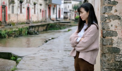 Woman standing by a canal feeling scared of life after divorce.