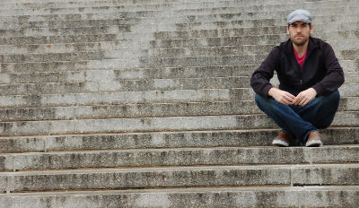 Man sitting on steps contemplating the difficulties of surviving a wife’s infidelity.
