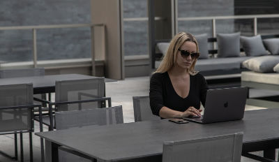 Woman wearing sunglasses to hide her tears as she reads divorce quotes on her laptop.