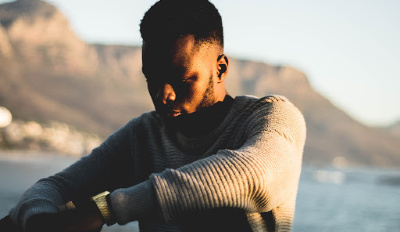 Man sitting on the beach struggling with his grief in divorce.