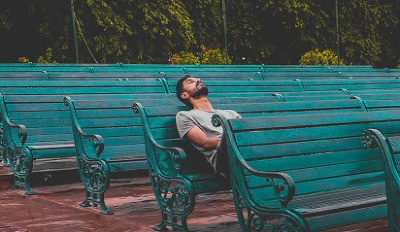 Sad man sitting on a bench struggling with ideas of how to overcome marital infidelity.