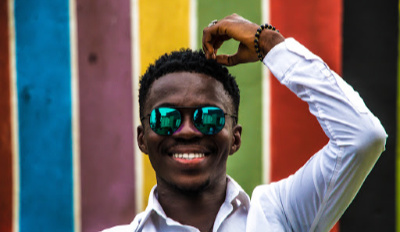 Man wearing sunglasses and smiling because he’s found his keys to a happy life.