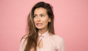 Woman wearing pink blouse looking scared by the realities of life after divorce from a narcissist.