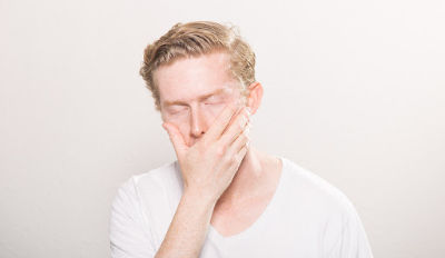 Frustrated man in white t-shirt struggling with his unrealistic expectations in marriage.