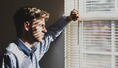 Man looking out a window wondering if healing a broken heart after divorce is possible.
