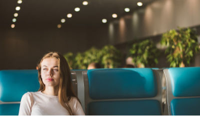 Woman sitting in a lounge thinking about how to get over resent after an affair.