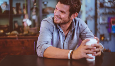 Smiling man sitting at a table enjoying his quality of life after divorce.