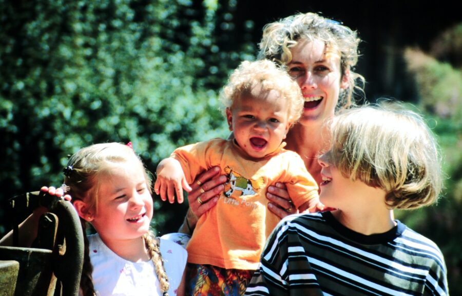 Woman, who’s struggling with rebuilding her life after divorce, outside with her 3 children.