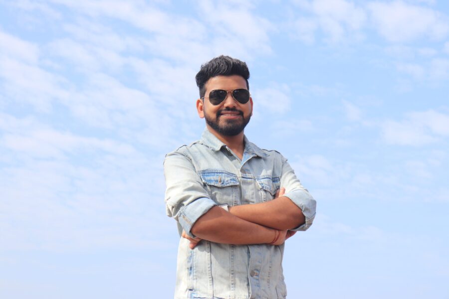 Man wearing sunglasses and smiling after reading success and happiness quotes.