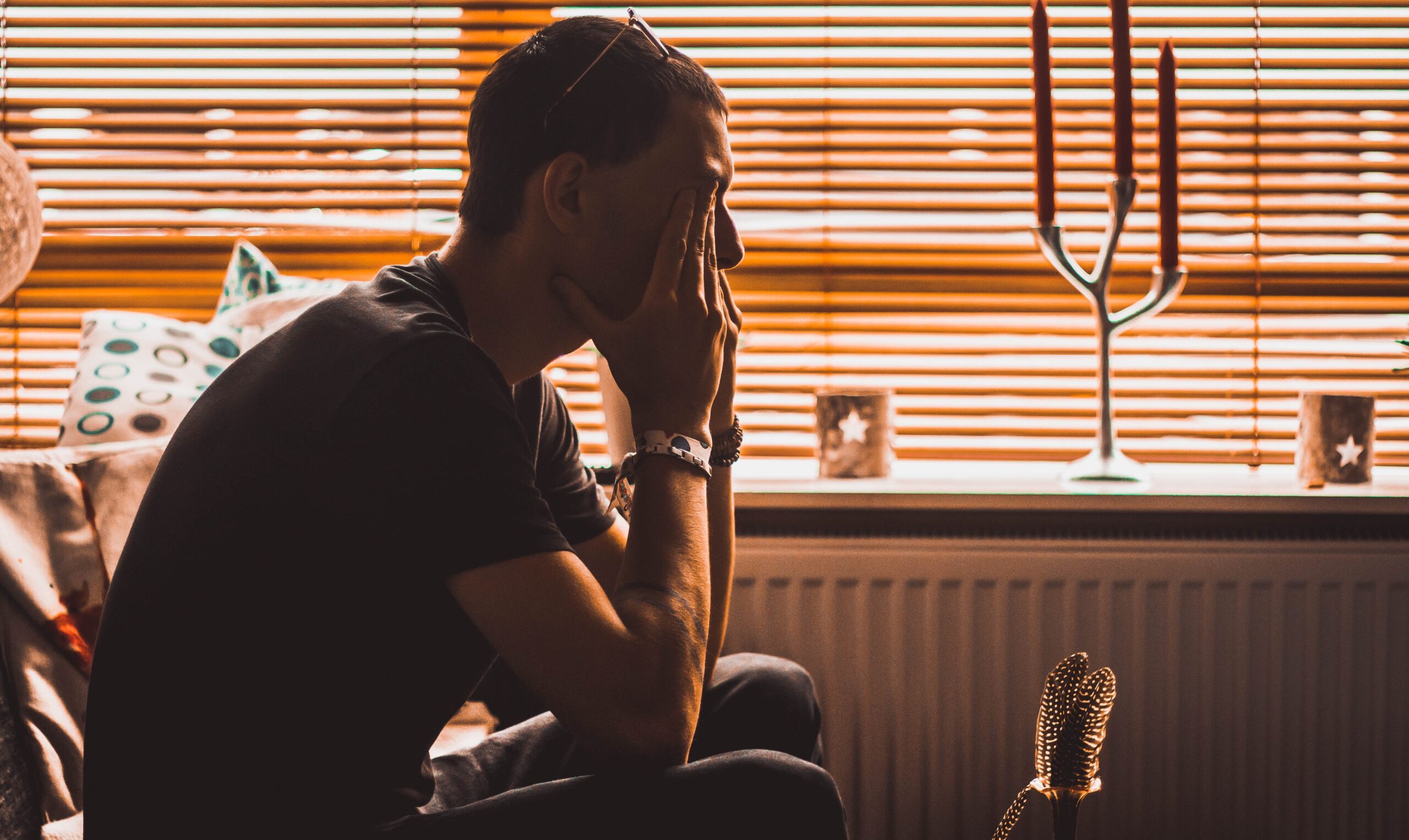 Man sitting with his hands covering his eyes as he struggles with life after divorce.