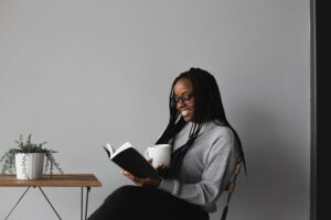 Woman sitting and smiling as she reads finding-happiness quotes.