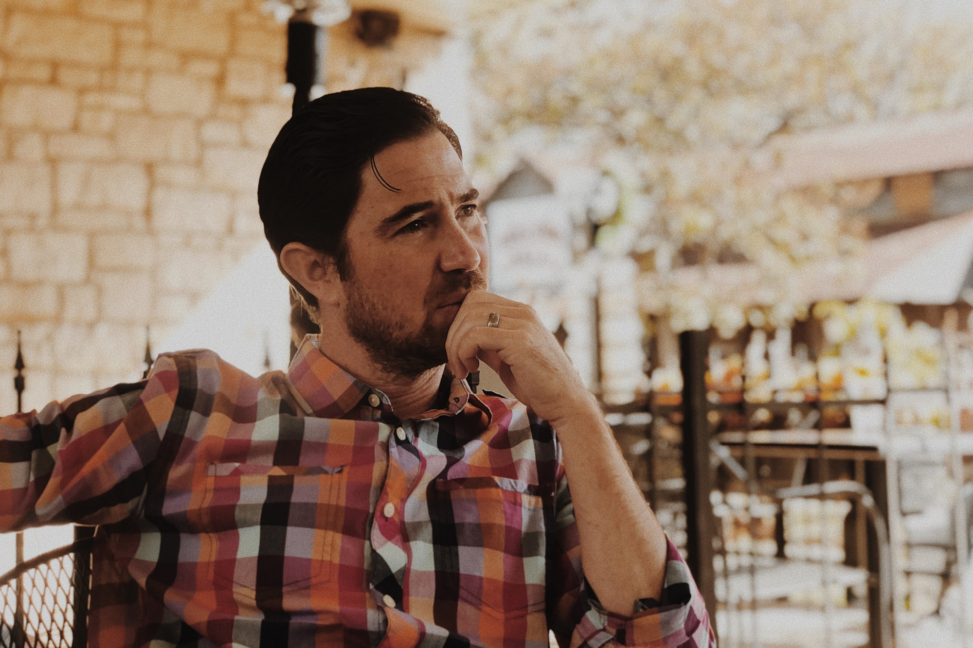 Man sitting at a table outside wondering how hard life would be after divorce.