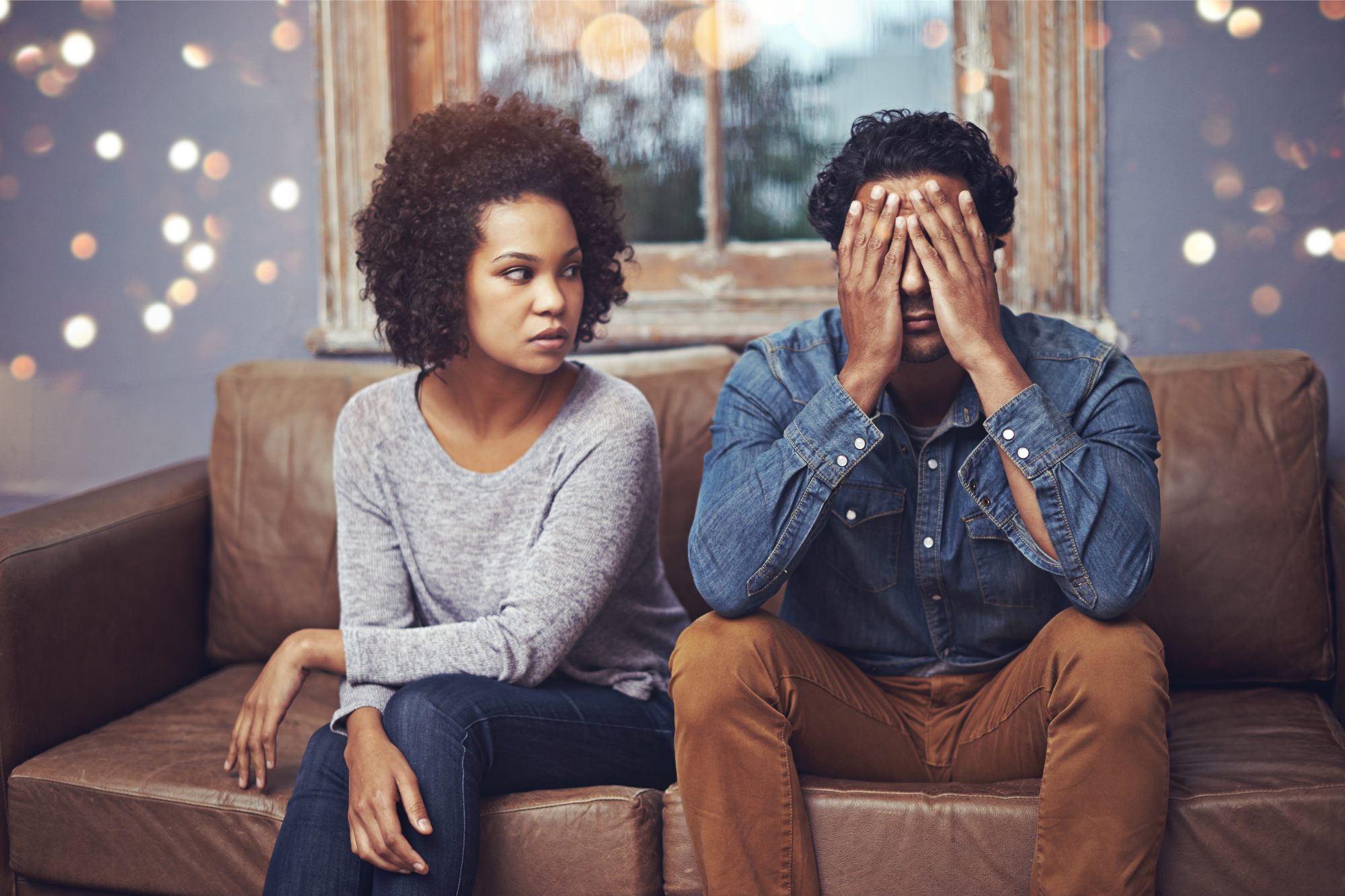 Unhappy couple sitting on a couch contemplating the signs of a bad marriage.