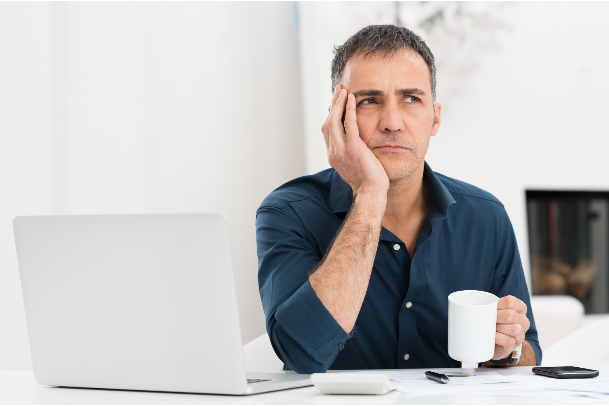 Unhappy man holding a cup of coffee and wondering if being happy again is possible.